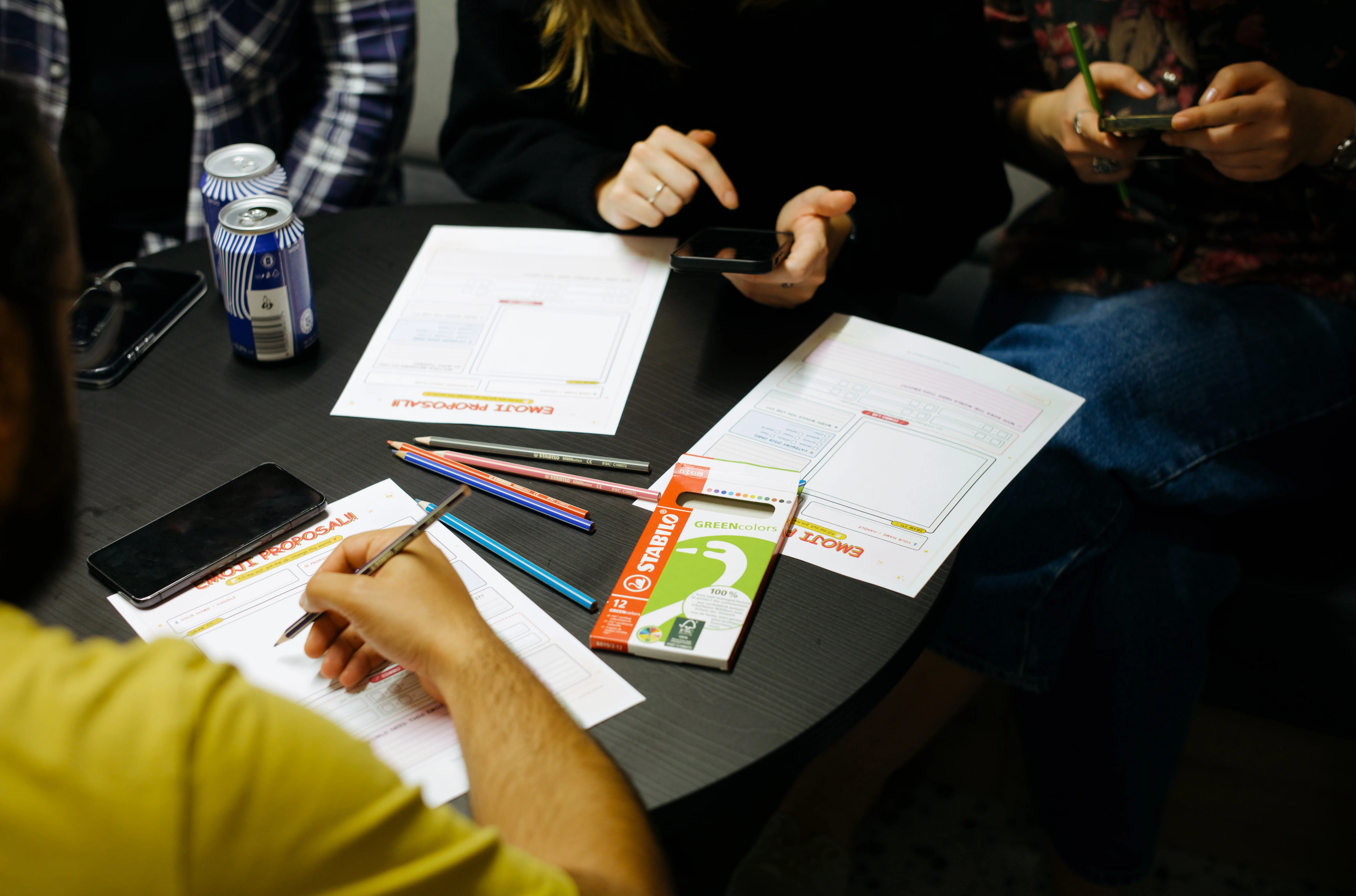 The crowd drawing their own emoji proposals on paper